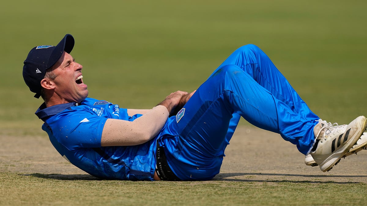 (AP Photo/Bikas Das) : Italy's captain Wayne Madsen reacts after a miss-fielding by him which hurt his hand during the T20 World Cup cricket match between Italy and Scotland in Kolkata, India, Monday, Feb. 9, 2026
