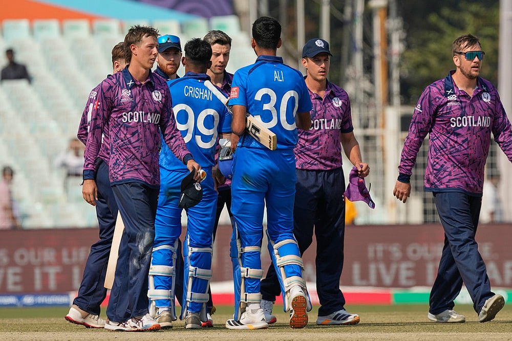 | Photo: AP/Bikas Das : Italy's Ali Hasan and Crishan Jorge congratulate Scotland players on wining the T20 World Cup cricket match in Kolkata.