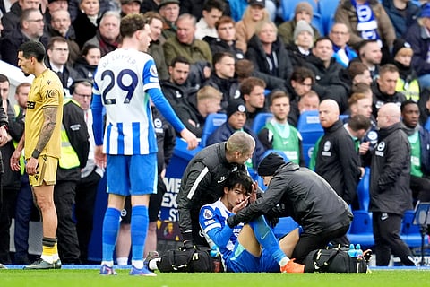 Brighton and Hove Albion's Kaoru Mitoma receives treatment during their English Premier League soccer match against Crystal Palace in Brighton, England.