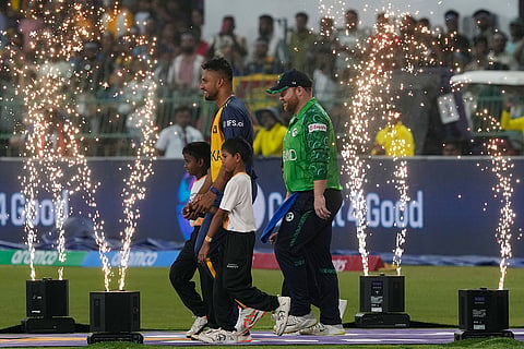 Sri Lanka's captain Dasun Shanaka, center left, and Ireland's captain Paul Stirling walk out on to the field before the start of the T20 World Cup cricket match between Sri Lanka and Ireland in Colombo, Sri Lanka.