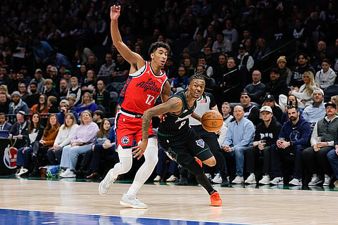 Minnesota Timberwolves guard Bones Hyland (8) drives to the basket while Los Angeles Clippers guard Cam Christie (12) defends during the first half of an NBA basketball game in Minneapolis. 