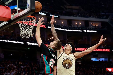 Memphis Grizzlies guard Cam Spencer, left, shoots against Golden State Warriors forward Gui Santos (15) during the first half of an NBA basketball game in San Francisco.