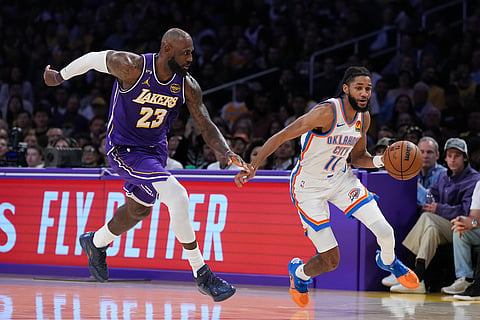 Oklahoma City Thunder guard Isaiah Joe (11) dribbles past Los Angeles Lakers forward LeBron James (23) during the second half of an NBA basketball game in Los Angeles. 
