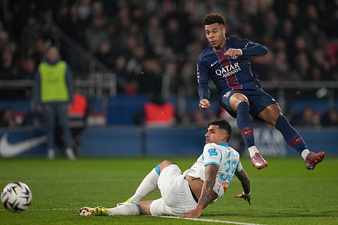 PSG's Desire Doue, right, and Marseille's Emerson Palmieri challenge for the ball during the French League One soccer match between Paris Saint-Germain and Marseille in Paris.