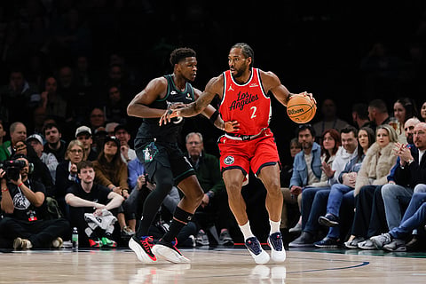 Los Angeles Clippers forward Kawhi Leonard (2) dribbles while Minnesota Timberwolves guard Anthony Edwards, left, defends during the first half of an NBA basketball game in Minneapolis.