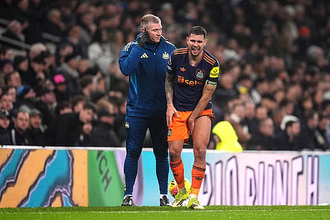 Newcastle United's Bruno Guimaraes, right, is helped off the field by medical staff following an injury  during a Premier League soccer match against Tottenham.