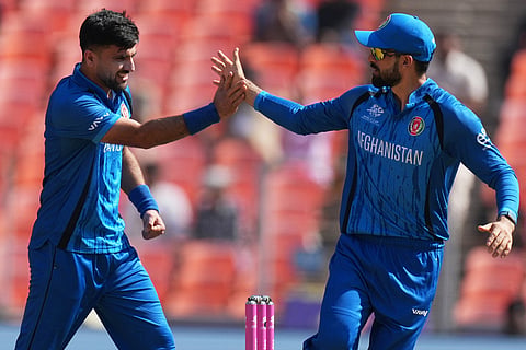 Afghanistan's Fazalhaq Farooqi, left celebrate the wicket of South Africa's captain Aiden Markram during the T20 World Cup cricket match between Afghanistan and South Africa in Ahmedabad.
