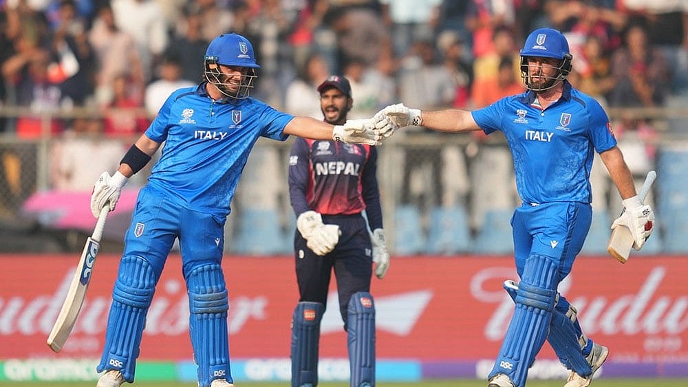 | Photo: AP/Rafiq Maqbool : Italy's Justin Mosca, left, Anthony Mosca, right, encourage each other as they bat during the T20 World Cup cricket match between Italy and Nepal in Mumbai, India.