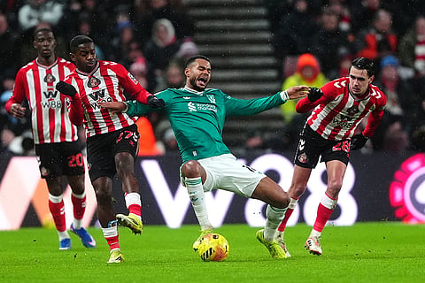 Liverpool's Cody Gakpo, center, battles with Sunderland's Noah Sadiki, left, and Enzo Le Fee, right, during their English Premier League soccer match, in Sunderland, England.