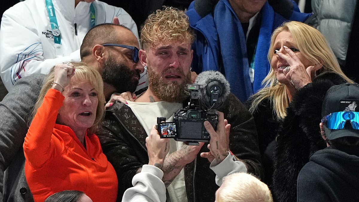 (AP Photo/Antonio Calanni) : Jake Paul of the U.S., center, cries after his fiancé Jutta Leerdam of the Netherlands won the gold medal in the women's 1,000 meters speedskating race at the 2026 Winter Olympics, in Milan, Italy, Monday, Feb. 9, 2026. 