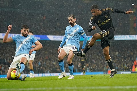Manchester City's Ruben Dias, left, tries to block a shot from Fulham's Alex Iwobi during the English Premier League soccer match between Manchester City and Fulham in Manchester, England.