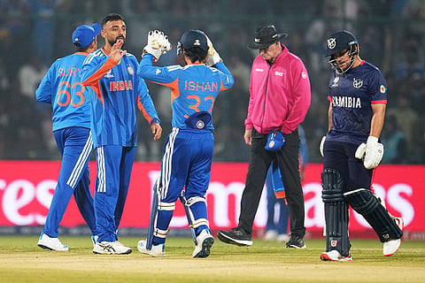 India's Varun Chakravarthy, second left, celebrates with teammate Ishan Kishan the wicket of Namibia's Nicol Loftie-Eaton, right, during the T20 World Cup cricket match between India and Namibia in New Delhi.