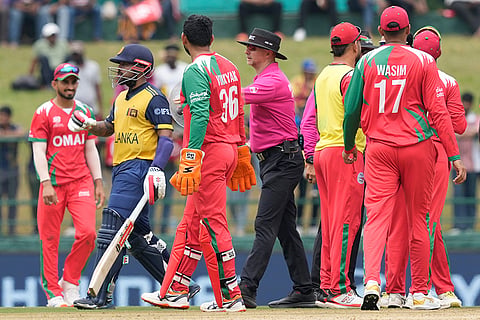 An Umpire, center, push back Sri Lanka's Kusal Mendis, second left, to avoid arguments with Oman's players during the T20 World Cup cricket match between Oman and Sri Lanka in Pallekele, Sri Lanka.
