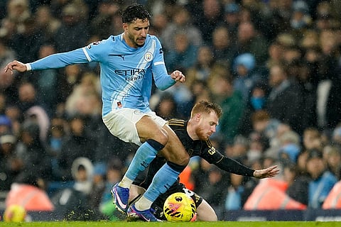 Manchester City's Omar Marmoush, left, and Fulham's Harrison Reed challenge for the ball during the English Premier League soccer match between Manchester City and Fulham in Manchester, England.