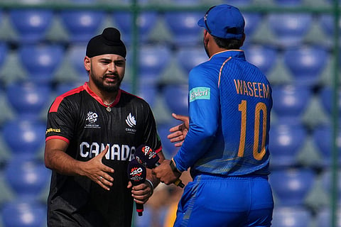 Canada's captain Dilpreet Bajwa, left and United Arab Emirates' captain Muhammad Waseem about to shake hands after the toss during the T20 World Cup cricket match between Canada and United Arab Emirates in New Delhi.