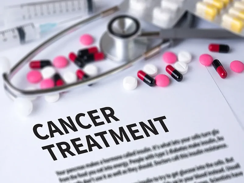 Cancer treatment document with stethoscope and assorted pills on desk