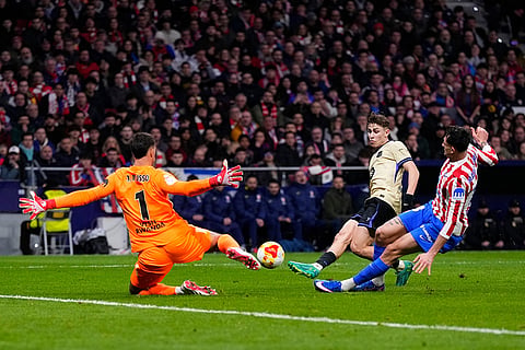 Atletico Madrid's goalkeeper Juan Musso, left, makes a save of a shot by Barcelona's Fermin Lopez, centre, during the Copa del Rey semifinal first leg soccer match between Atletico Madrid and Barcelona in Madrid, Spain.