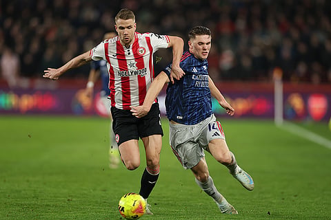 Brentford's Kristoffer Ajer, left, and Arsenal's Jurrien Timber fight for the ball during the English Premier League soccer match between Brentford and Arsenal in London.