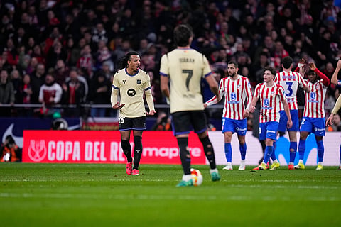Barcelona's Jules Kounde, left, reacts after Atletico Madrid's Ademola Lookman scored his side's third goal during the Copa del Rey semifinal first leg soccer match between Atletico Madrid and Barcelona in Madrid, Spain.