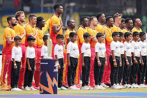 Zimbabwe's players stand up for the national anthems before the start of the during the T20 World Cup cricket match between Australia and Zimbabwe in Colombo, Sri Lanka.