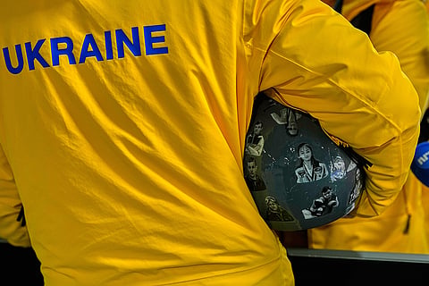 Ukrainian skeleton athlete Vladyslav Heraskevych holds his crash helmet as he stands in the mixed zone of the sliding center at the 2026 Winter Olympics, in Cortina d'Ampezzo, Italy.