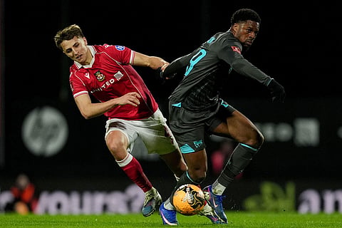 Wrexham's Max Cleworth, left, and Ipswich Town's Chuba Akpom battle for the ball  during an English FA Cup fourth round soccer in Wrexham, Wales.