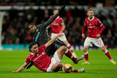 Wrexham's George Dobson, bottom, and Ipswich Town's Jens Cajuste battle for the ball during an English FA Cup fourth round soccer in Wrexham, Wales.