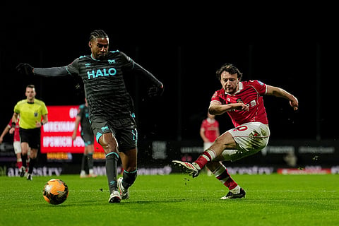 Wrexham's Ollie Rathbone, right, has a shot at goal against Ipswich Town  during an English FA Cup fourth round soccer in Wrexham, Wales.