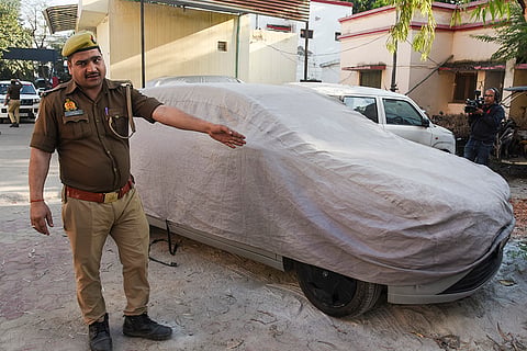 A police officer stands beside a parked car where a man allegedly shot himself and his girlfriend, in Noida. A 32-year-old man allegedly shot his 26-year-old girlfriend before turning the gun on himself inside a parked car in Sector 107 here, police said on Saturday. 