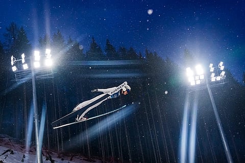 Song Qiwu, of China, soars through the air during the ski jumping men's large hill individual at the 2026 Winter Olympics, in Predazzo, Italy.