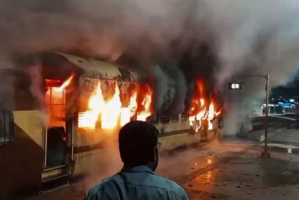 | Photo: PTI : A coach of an empty passenger train catches fire at Katwa railway station, in Purba Bardhaman district, West Bengal.