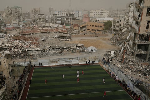 Palestinian players of Gaza Sports Club and Al-Ahly Club take part in a soccer match at a newly constructed field surrounded by buildings destroyed in Israeli ground and air operations, in Gaza City.