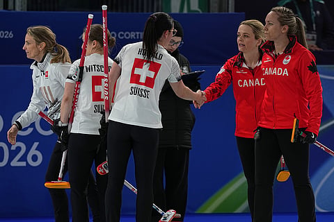 Switzerland's Carole Howald shakes hands with Canada's Tracy Fleury after the women's curling round robin session at the 2026 Winter Olympics, in Cortina d'Ampezzo, Italy.