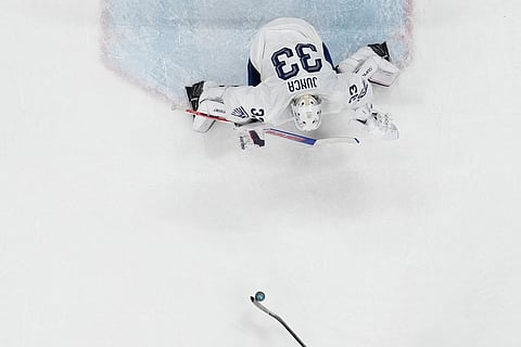 Canada's Macklin Celebrini (17) scores on a penalty shot against France's goalkeeper Julian Junca (33) in the second period during a preliminary round game of men's ice hockey between Canada and France at the 2026 Winter Olympics, in Milan, Italy.