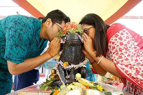 A couple whispers wishes into Nandi's ear at a Lord Shiva temple, a day after the 'Mahashivratri' festival, in Agartala, Tripura.