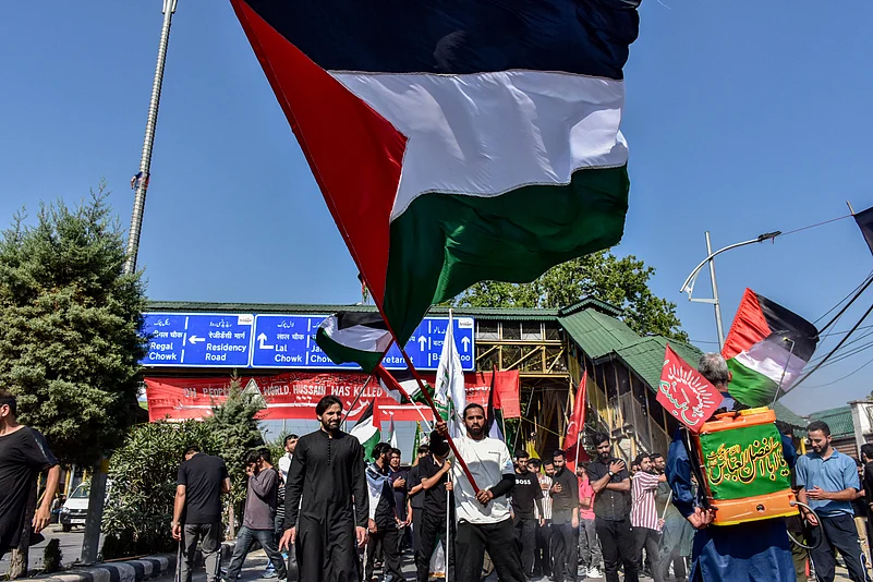 A Kashmiri Shiite Muslim holds a Palestinian flag to express solidarity with Palestinians in Gaza,