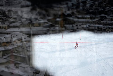 Spain's Joachim Salarich is photographed through a window as he arrives at the finish area during an alpine ski men's slalom race at the 2026 Winter Olympics in Bormio, Italy.