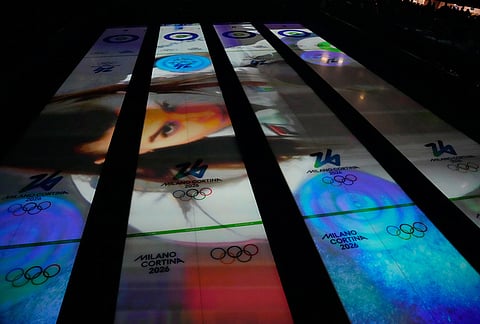 Images are projected on the sheets of ice before a men's curling round robin session at the 2026 Winter Olympics, in Cortina d'Ampezzo, Italy.