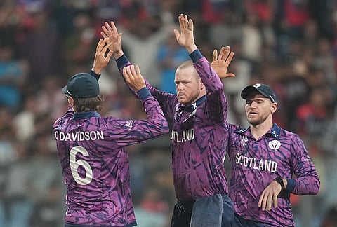 Scotland's Michael Leask celebrates the wicket of Nepal's Aasif Sheikh with teammates during the T20 World Cup cricket match between Nepal and Scotland in Mumbai.