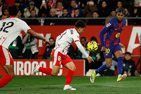 Barcelona's Lamine Yamal fights for the ball against Girona's Fran Beltran during a Spanish La Liga soccer match between Girona and Barcelona in Girona, Spain.