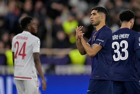 PSG's Achraf Hakimi, center, celebrates after scoring his side's second goal during the first-leg of the Champions League playoff soccer match between Monaco and Paris Saint-Germain in Monaco.