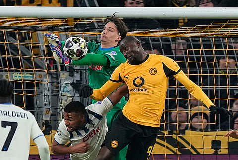 Atalanta's goalkeeper Marco Carnesecchi and Dortmund's Serhou Guirassy go for the ball during the Champions League knockout playoff first leg soccer match between Borussia Dortmund and Atalanta in Dortmund, Germany.