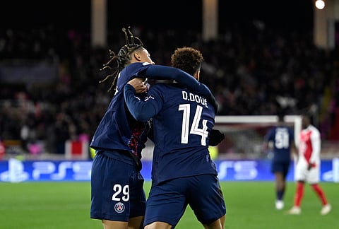 PSG's Desire Doue, right, celebrates with PSG's Bradley Barcola after scoring his side's opening goal during the first-leg of the Champions League playoff soccer match between Monaco and Paris Saint-Germain in Monaco.