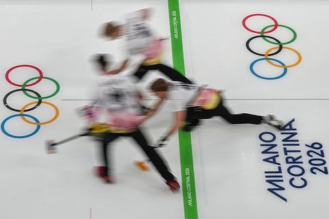 Germany's Benjamin Kapp, Felix Messenzehl, and Johannes Scheuerl in action during the men's curling round robin session against Czechia, at the 2026 Winter Olympics, in Cortina d'Ampezzo, Italy.
