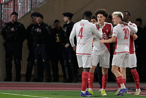 Monaco's Folarin Balogun celebrates with teammates after scoring his side's second goal during the first-leg of the Champions League playoff soccer match between Monaco and Paris Saint-Germain in Monaco.