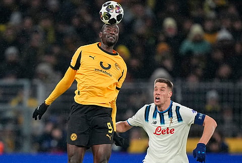 Dortmund's Serhou Guirassy heads the baaa above Atalanta's Mario Pasalic during the Champions League Knockout playoff 1st leg soccer match between Borussia Dortmund and Atalanta in Dortmund, Germany.