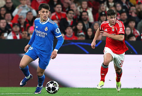 Real Madrid's Arda Guler fights for the ball against Benfica's Samuel Dahl during a Champions League opening phase soccer match between SL Benfica and Real Madrid in Lisbon, Portugal.