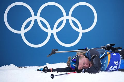 Johanna Talihaerm, of Estonia, collapses in the finish area of the women's 4x6-kilometer relay biathlon race at the 2026 Winter Olympics in Anterselva, Italy.
