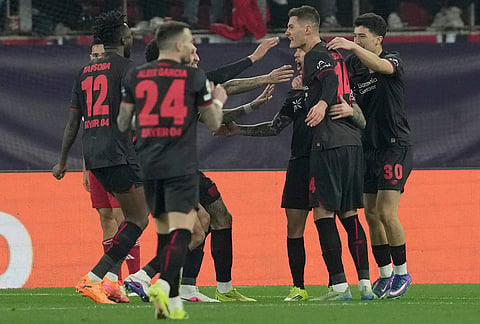 Leverkusen players celebrate after a goal during a Champions League playoff soccer match between Olympiacos and Bayer 04 Leverkusen in Piraeus port, near Athens.