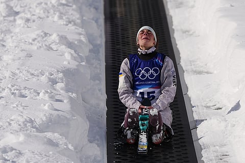 Ukraine's Anhelina Brykina (15) reacts as she rides up the magic carpet during the women's freestyle skiing aerials qualifications at the 2026 Winter Olympics, in Livigno, Italy.